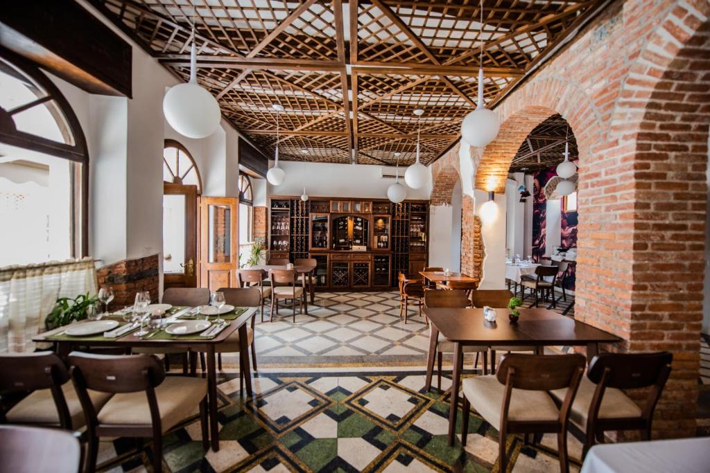 a room with tables and chairs and a brick wall at Hotel Loredano in Shkodër