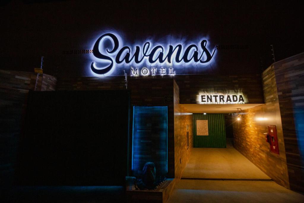 a neon sign on the side of a building at Savanas Motel in Ponta Grossa
