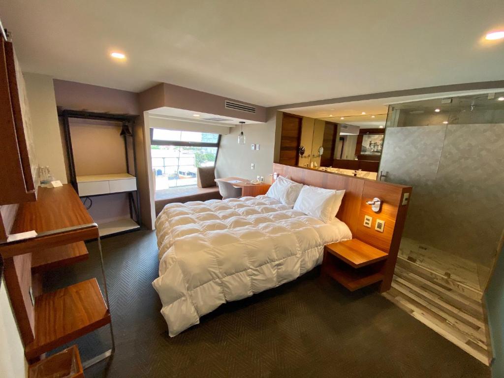 a bedroom with a large bed and a bathroom at Hotel Clé Reforma Insurgentes in Mexico City