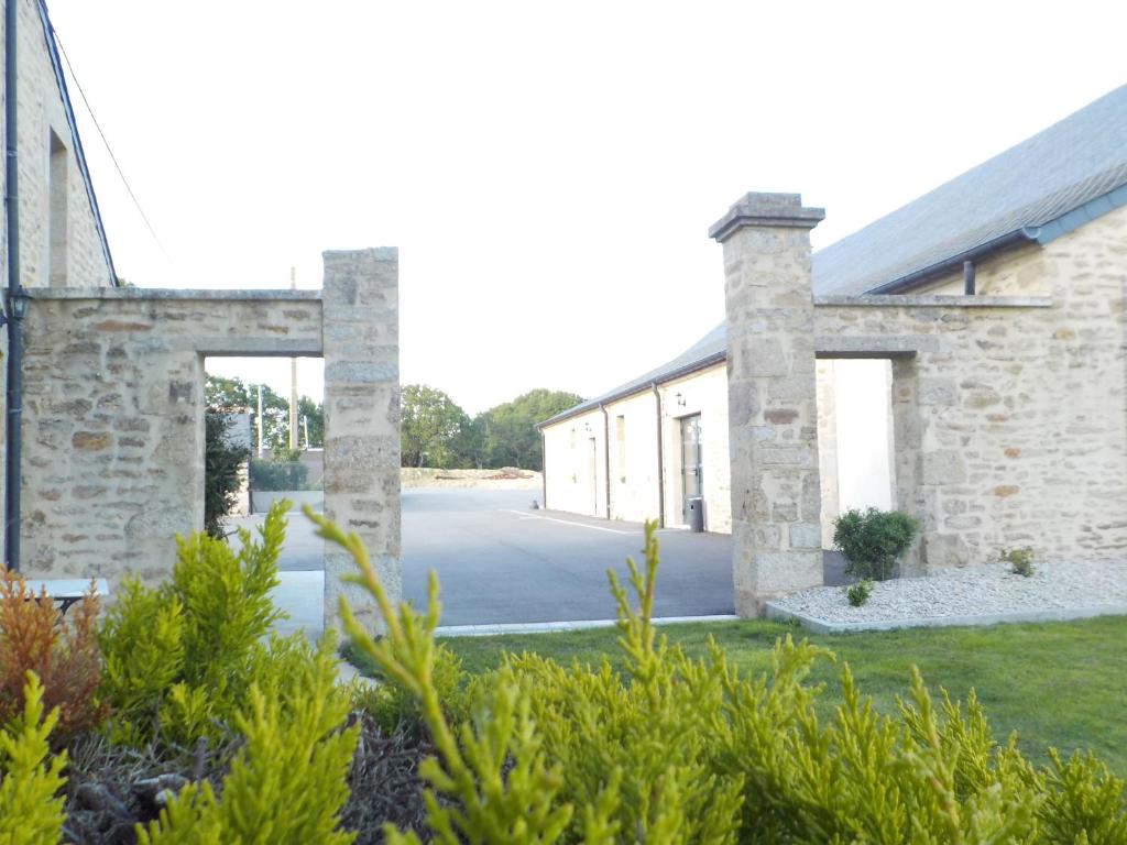 an exterior view of a stone building with a driveway at Domaine de kerbillec in Theix