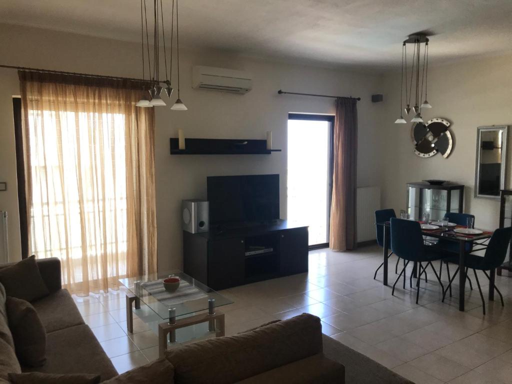 a living room with a couch and a table at Apartment on the Beach with View in Rethymno Town