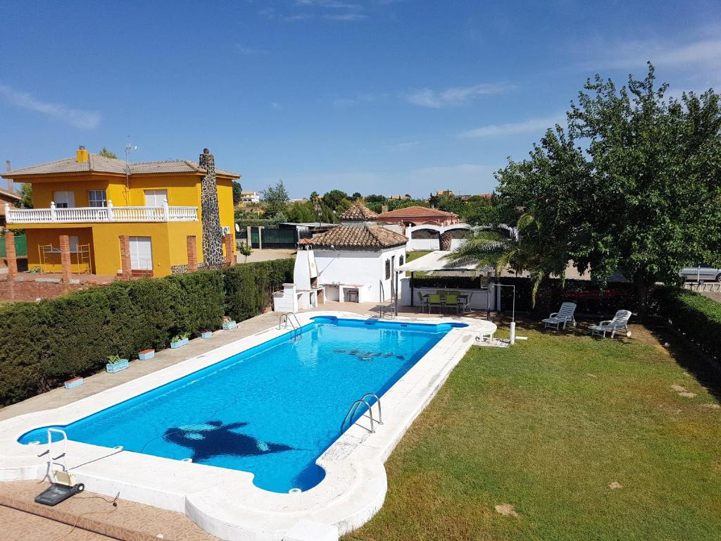 a swimming pool in a yard next to a house at 3 bedrooms villa with private pool enclosed garden and wifi at Linares in Jaén