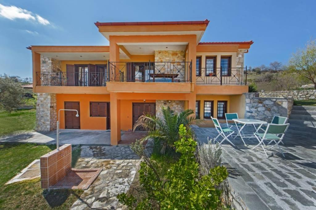 a house with a balcony and a table and chairs at Danai House in Nea Roda