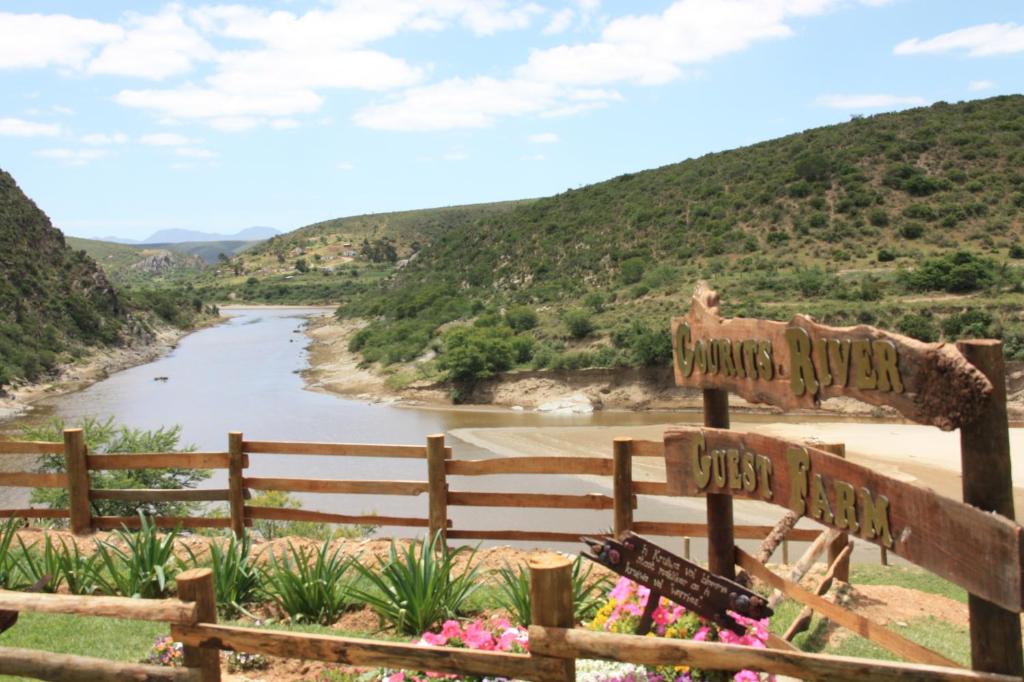 un cartel con un río y montañas en el fondo en Gourits River Guest Farm en Albertinia