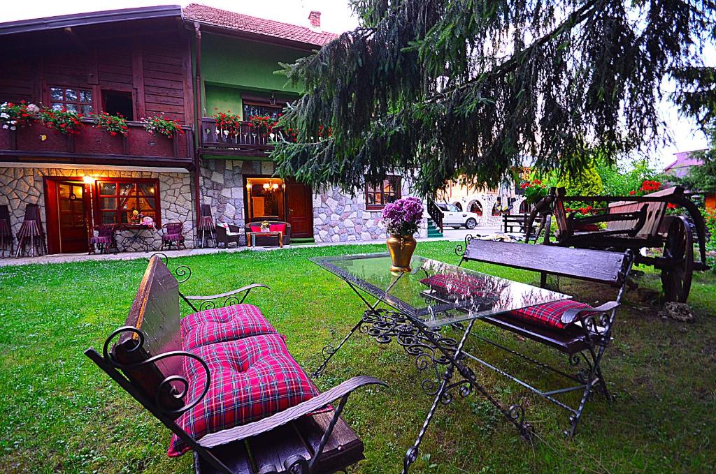 einen Tisch und Stühle im Hof eines Hauses in der Unterkunft Villa Miris Dunja in Zlatibor