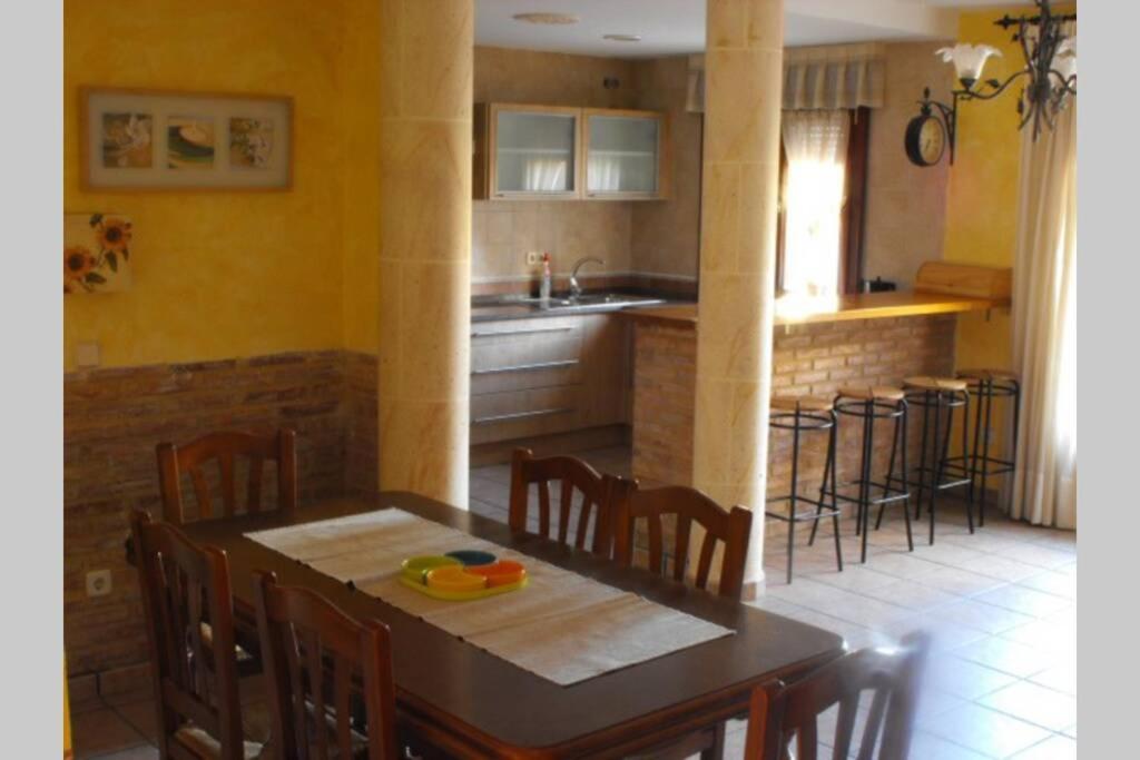 cocina con mesa, sillas y barra en CASA RURAL ALTA YUBERIA en Berlanga de Duero