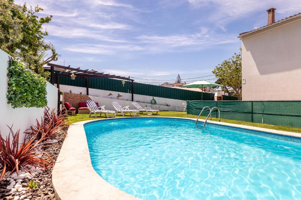 una piscina en un patio con sillas junto a una casa en Meco´s Village, en Aldeia do Meco
