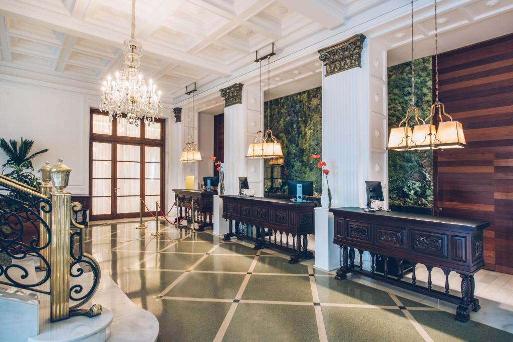 a room with desks and chairs and a chandelier at Iberostar Heritage Grand Mencey in Santa Cruz de Tenerife