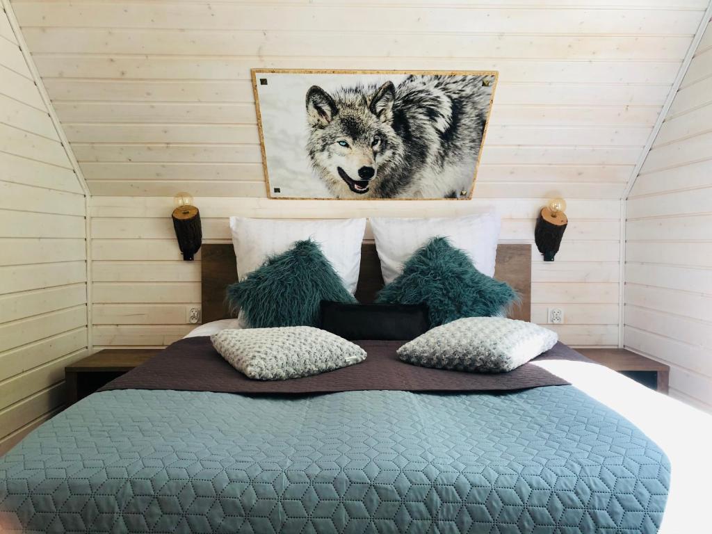 Schlafzimmer mit einem Bett mit Wolfsbild an der Wand in der Unterkunft U Wikinga - Domki letniskowe w Mielnie in Mielno