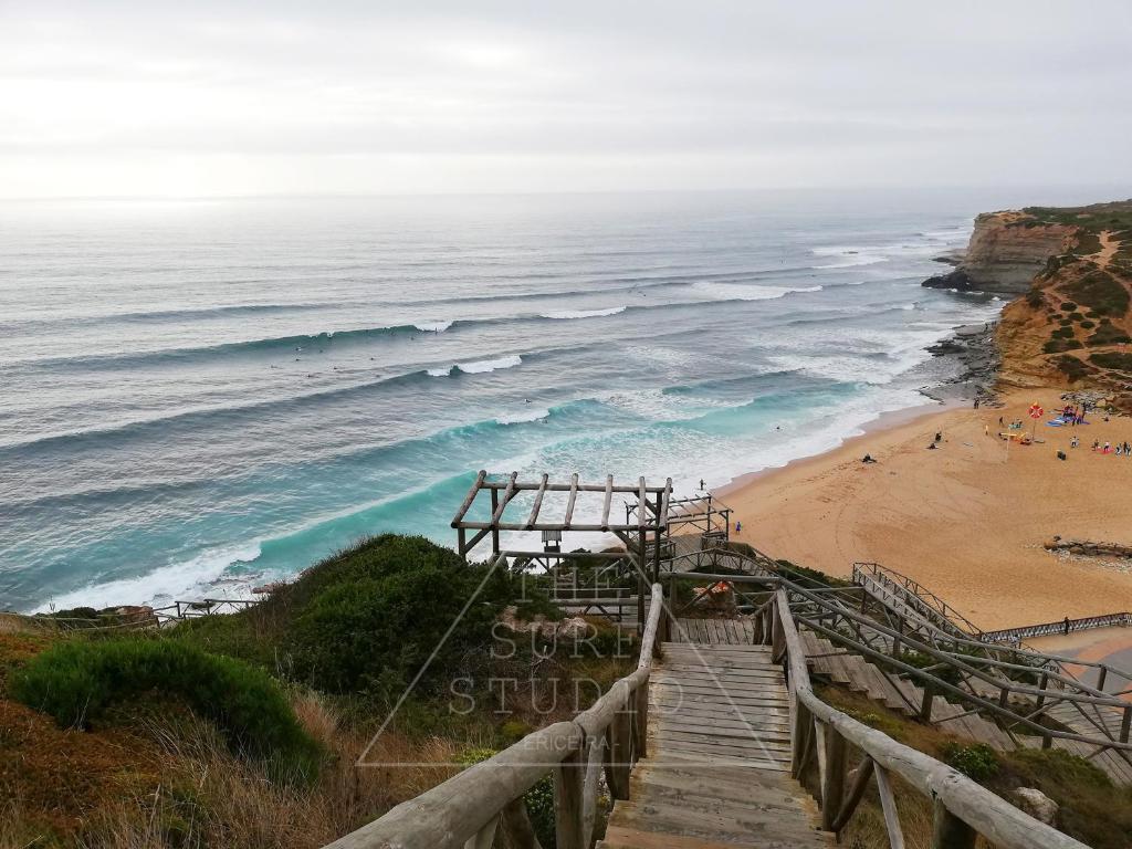 a stairway leading down to a beach with the ocean at The Surf Studio - Ericeira in Ericeira