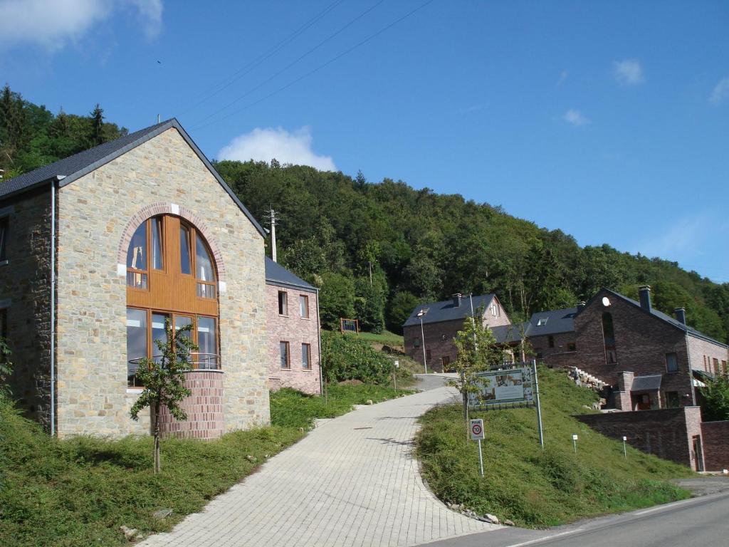 um edifício de tijolos numa colina ao lado de uma estrada em L'Oree De Bomal em Durbuy