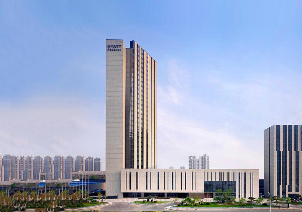 un grand bâtiment blanc au milieu d'une ville dans l'établissement Hyatt Regency Tianjin East, à Tianjin
