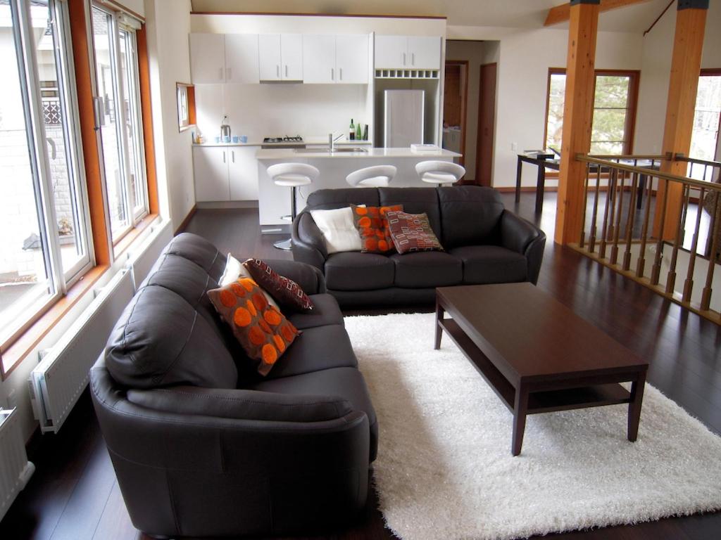 un soggiorno con divano e tavolo di Furano Lodge 10 a Furano