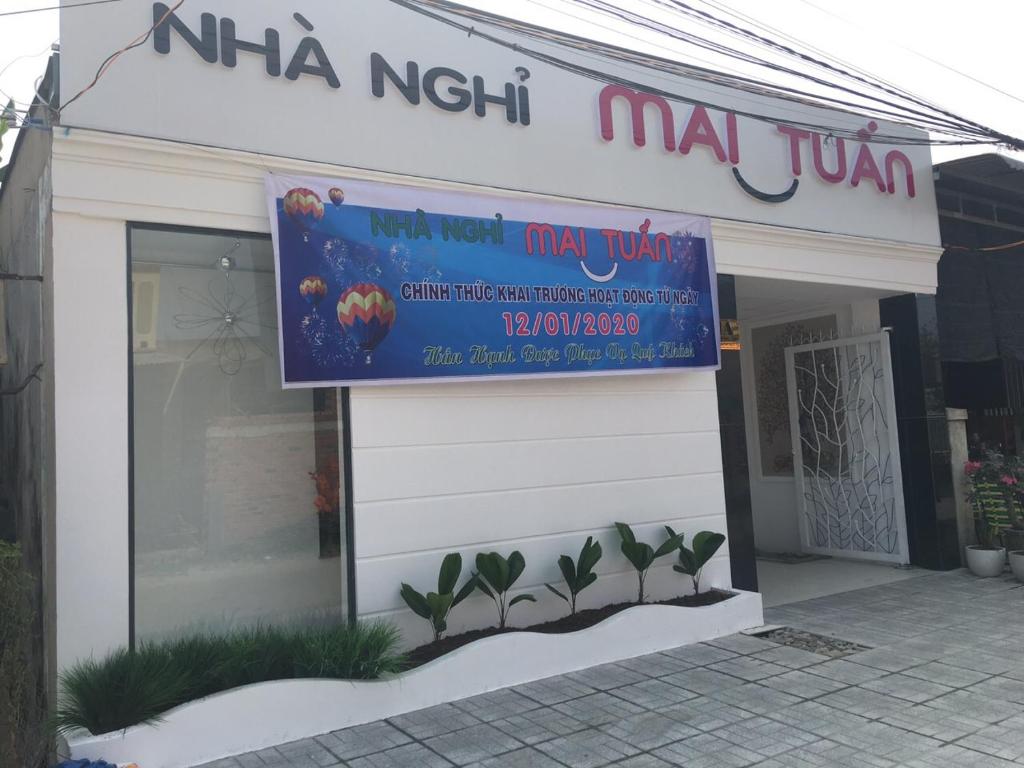 un cartello sul lato di un edificio con piante di Hotel MAI TUAN Phạm Hùng a Ấp Trường Huê
