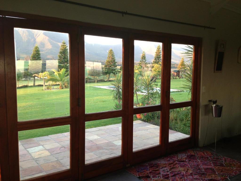 an open glass door with a view of a yard at Esperanza Countryside Accomodation in George