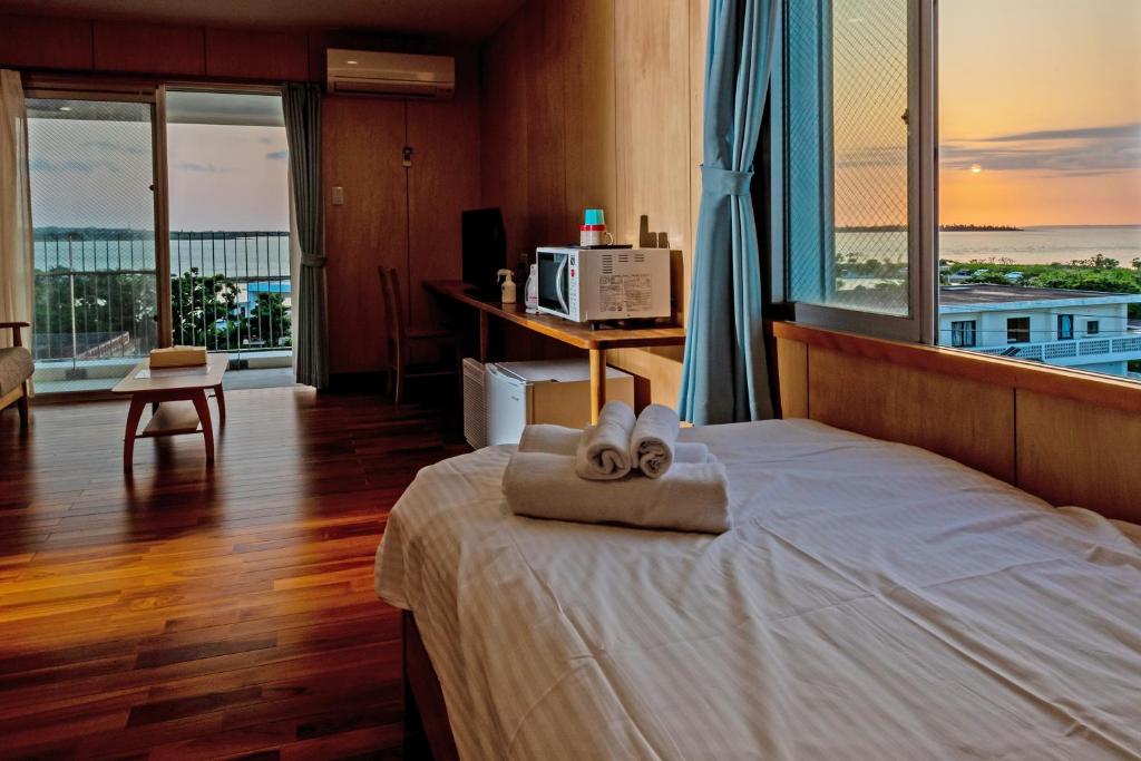 um quarto de hotel com uma cama com duas toalhas em Guest house Kawamitsu em Ilhas Miyako