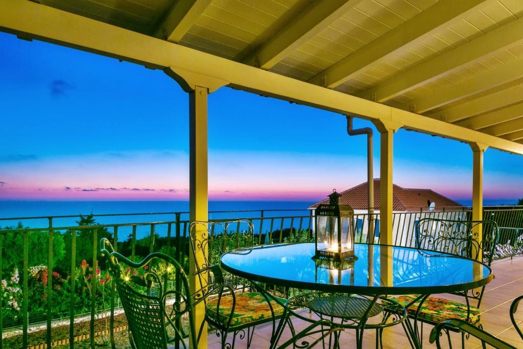 a table and chairs on a balcony with the ocean at Spacious Apartment with Sea View in Tzamarelata - 90 m² in Tzamarelláta