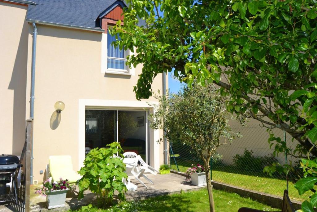 サン・ジュアン・デ・ゲレにあるMaison de 2 chambres avec jardin clos et wifi a Saint Jouan des Guerets a 1 km de la plageのテーブルと椅子のある庭園付きの家