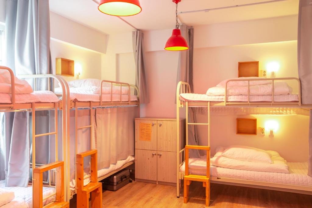 a room with four bunk beds in a hostel at SUM Guesthouse Jeju Airport in Jeju