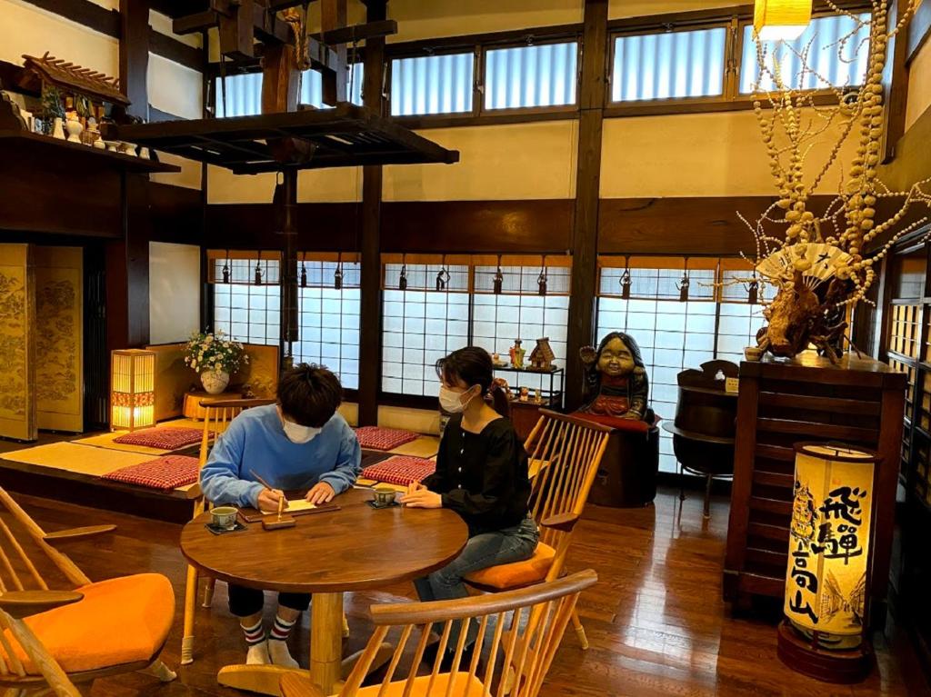 two people sitting at a table in a restaurant at Ryokan Asunaro in Takayama