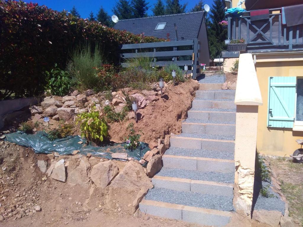 a garden with stairs leading to a house at Appartement de 2 chambres avec vue sur le lac jardin clos et wifi a Salles Curan in Salles-Curan