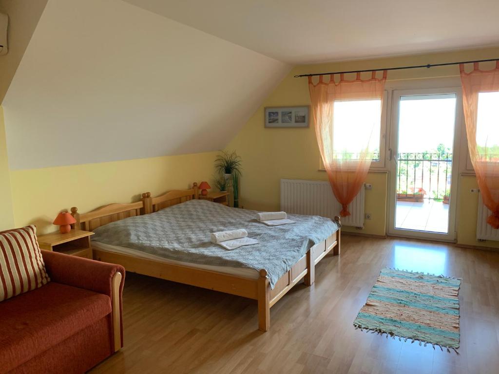 sypialnia z łóżkiem i kanapą w obiekcie HolidaySport Haus w mieście Balatongyörök