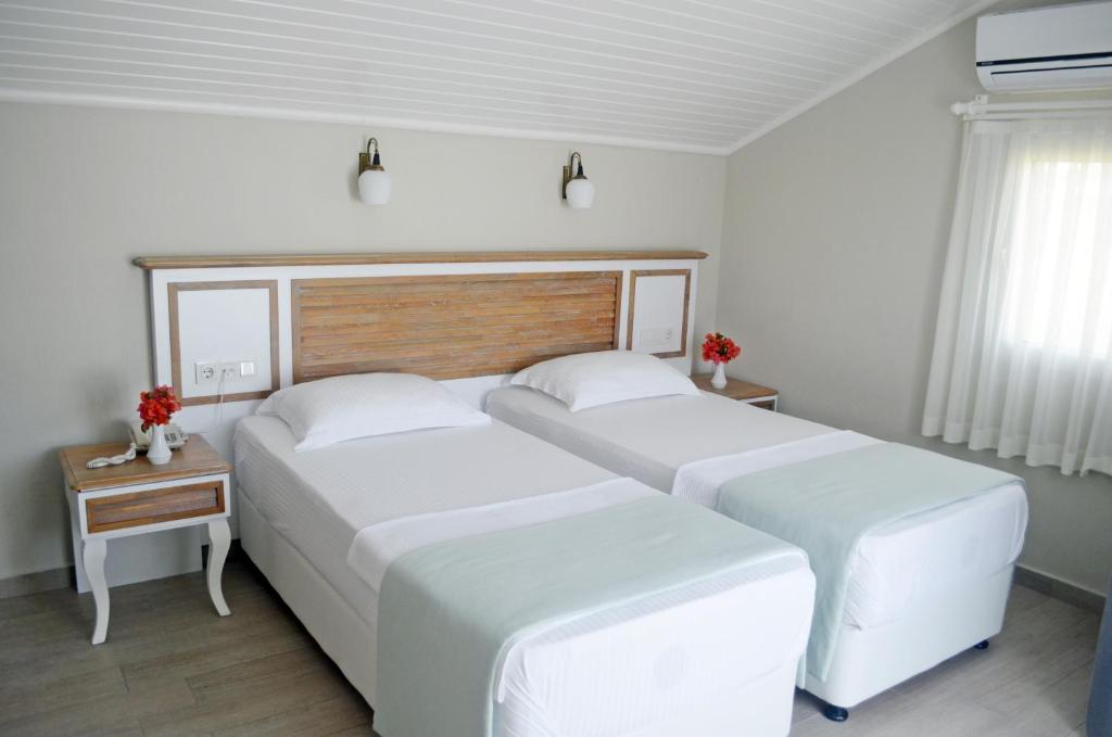 Postel nebo postele na pokoji v ubytování Datca Beyaz Ev Hotel