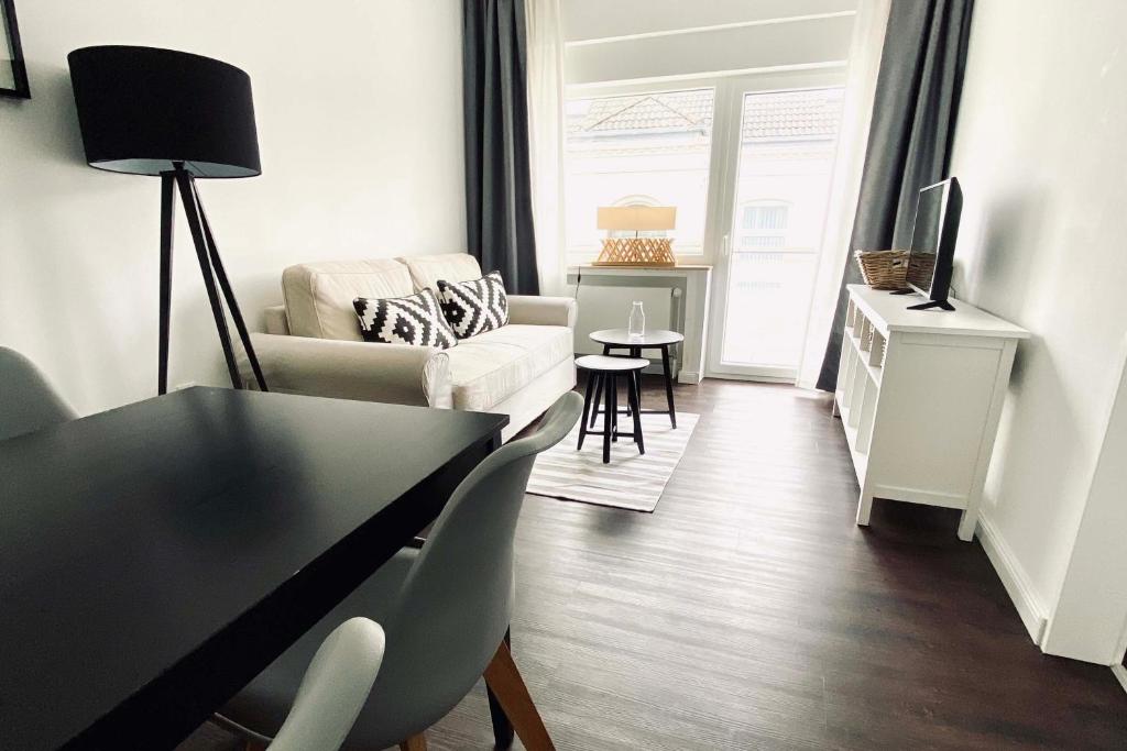ein Wohnzimmer mit einem Sofa, einem Tisch und Stühlen in der Unterkunft Haus Lieke Deeler in Norderney