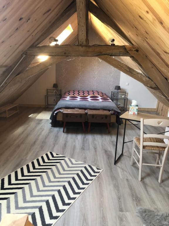 een zolderkamer met een bed en een tafel bij Le petit Candy in Amboise