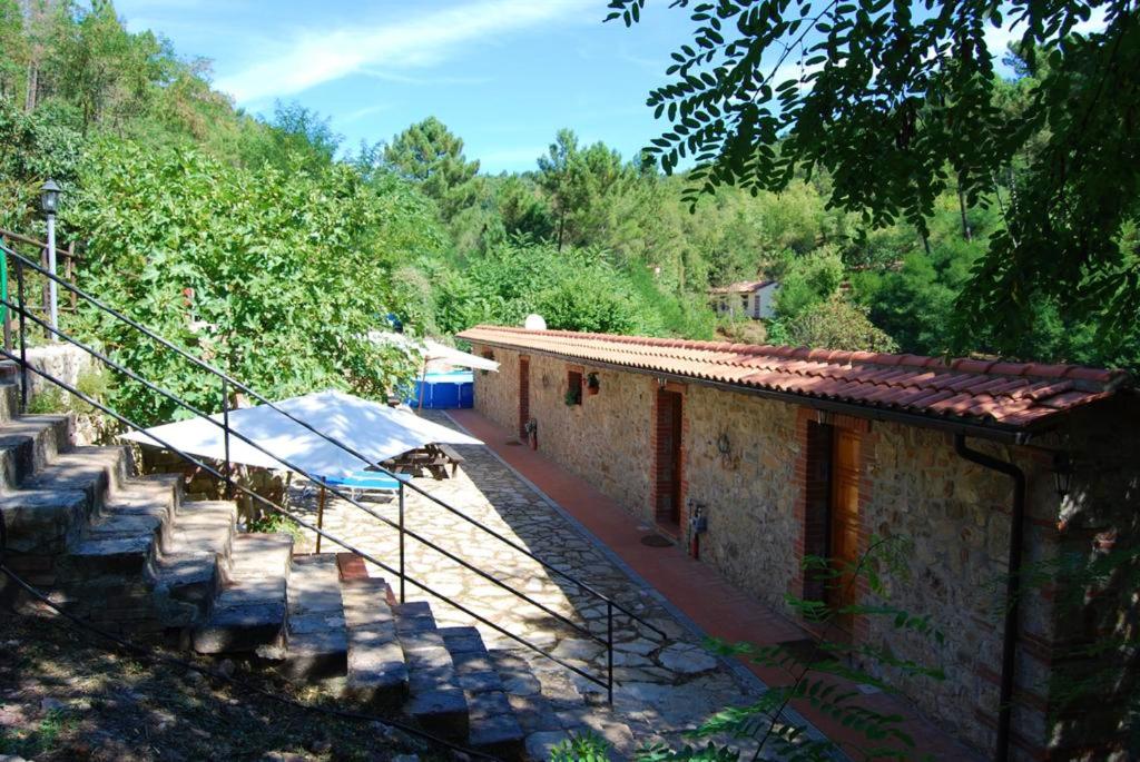 une maison avec un escalier à côté d'un bâtiment dans l'établissement 2 bedrooms apartement with shared pool and wifi at Massa Marittima, à Massa Marittima