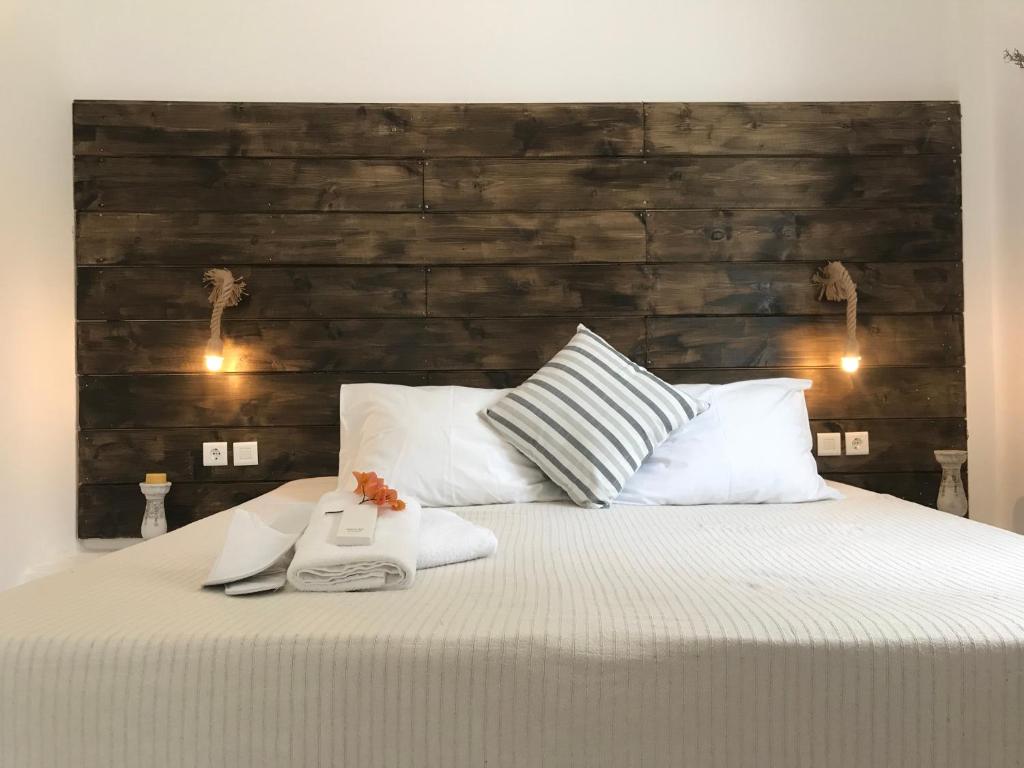a bedroom with a large bed with a wooden headboard at Ammos Luxury Studios in Aliki