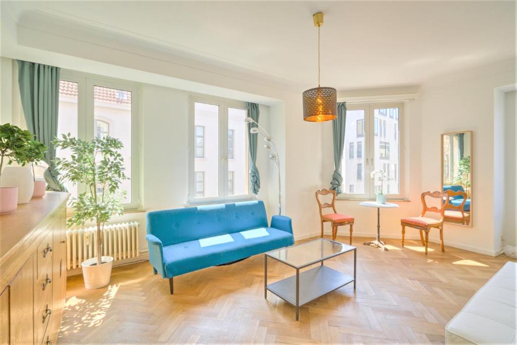 un soggiorno con divano blu e tavolo di Cauliflower Lodge. Apartment in Heart of Antwerp ad Anversa