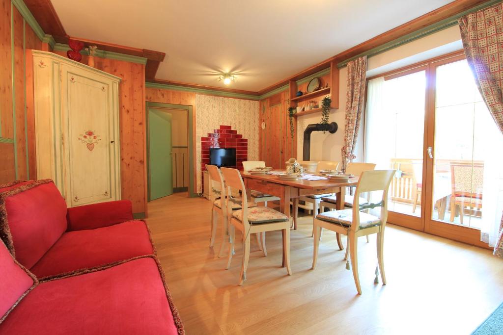 sala de estar con mesa y sofá rojo en NOCKFLAIR Apartment by Isa Agentur, en Bad Kleinkirchheim
