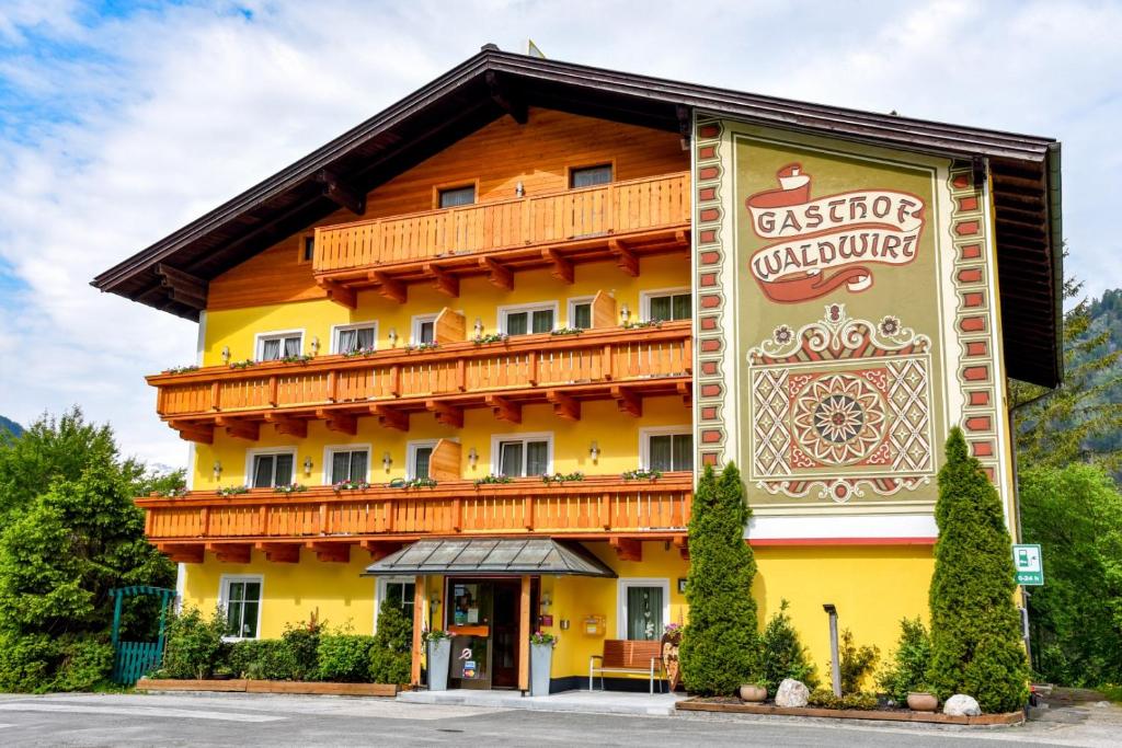 ein großes Gebäude mit einem Schild davor in der Unterkunft Gasthof Waldwirt in Russbach am Pass Gschütt