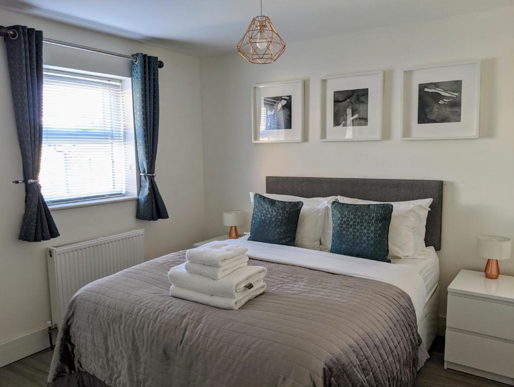 1 dormitorio con 1 cama con toallas en Saffron Court by Wycombe Apartments - Apt 06 en High Wycombe