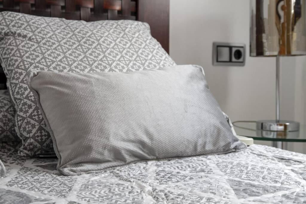 łóżko z poduszką na górze w obiekcie Penthouse Raggio w Sewilli