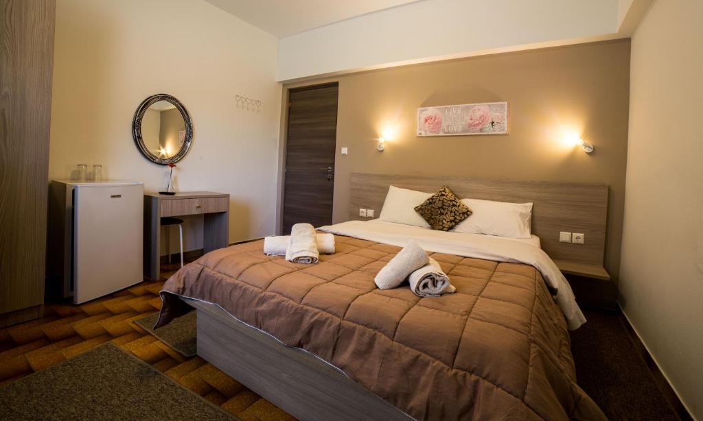 a hotel room with a large bed with a mirror at Stalaktites in Ioannina