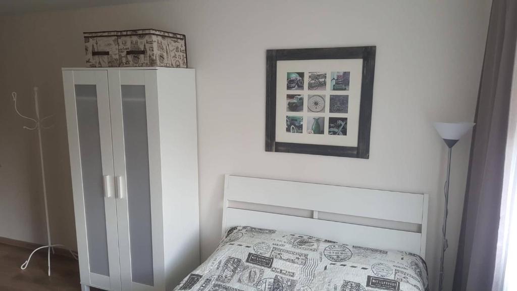 - une chambre avec un lit et une photo sur le mur dans l'établissement Apartment for You, à Klaipėda