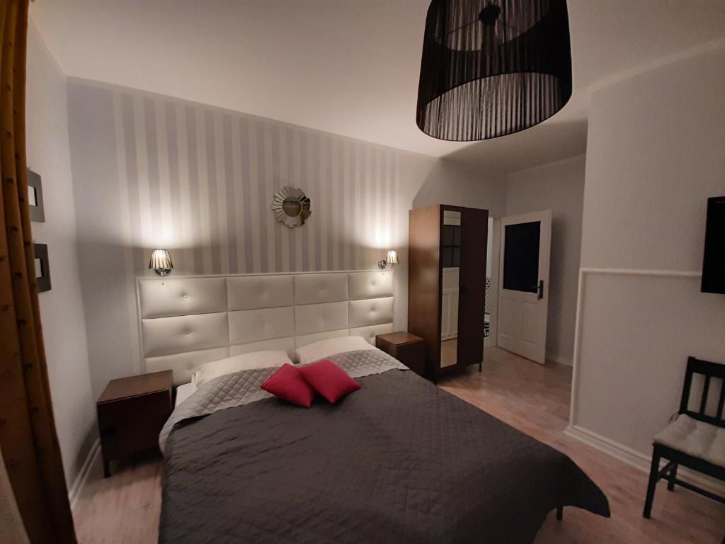 sypialnia z łóżkiem z 2 czerwonymi poduszkami w obiekcie Villa Senso w Busku Zdroju