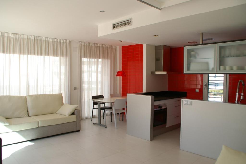 a kitchen and living room with a couch and a table at Apartamentos en Rocamaura in L'Estartit
