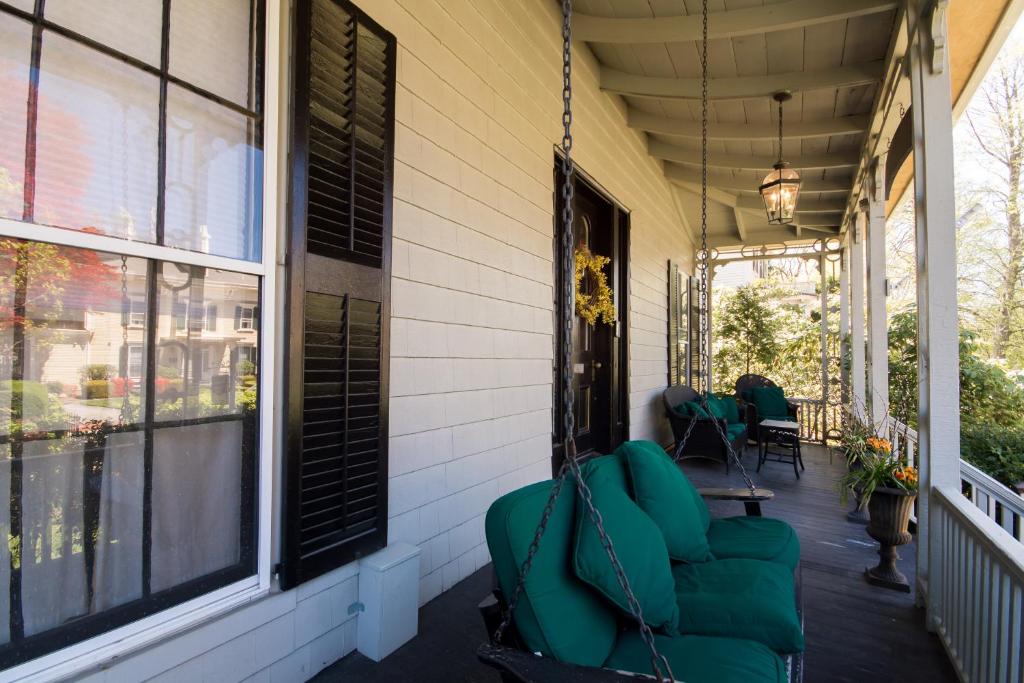 a porch with green chairs on a house at Marshall Slocum Inn in Newport
