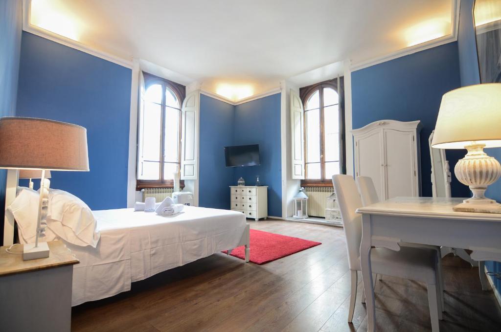 a bedroom with blue walls and a table and a bed at Speziali - Deluxe 2 bedroom flat nearby Piazza Repubblica in Florence