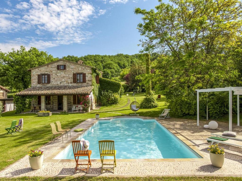une piscine avec deux chaises et une maison dans l'établissement Belvilla by OYO Camelle, à Fermignano