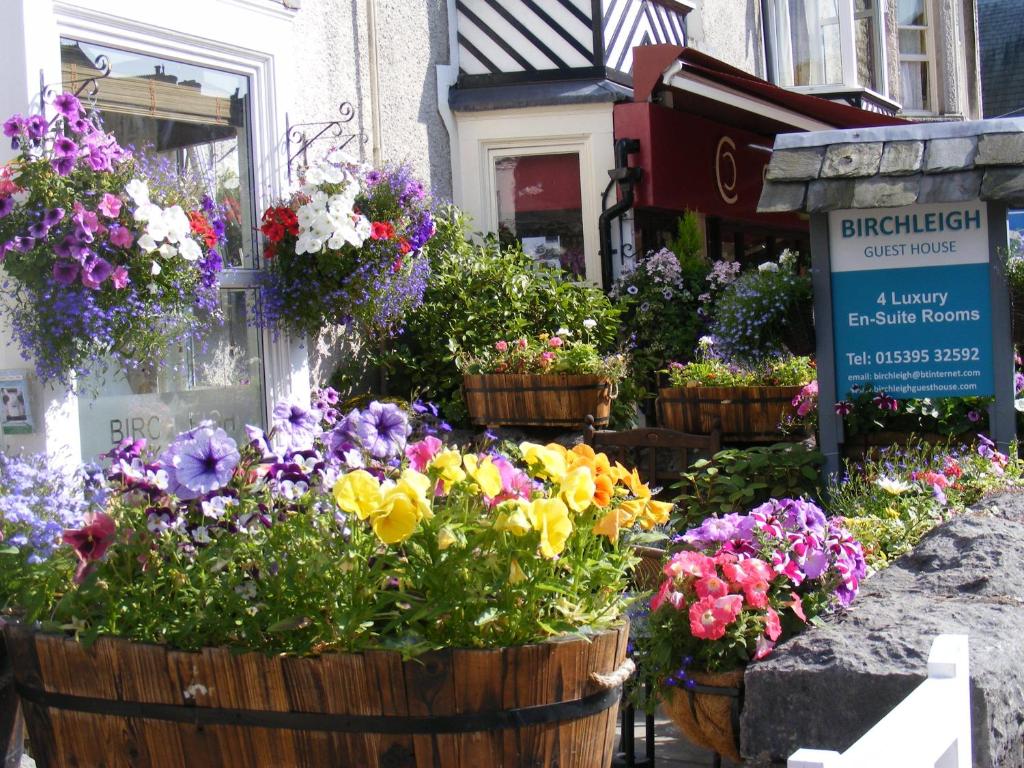 a bunch of flowers in baskets on a street at Birchleigh Guest House in Grange Over Sands