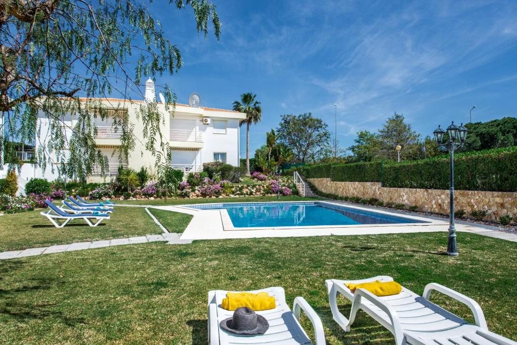 a backyard with a swimming pool and a house at Apartment Galé Garden 1A in Albufeira