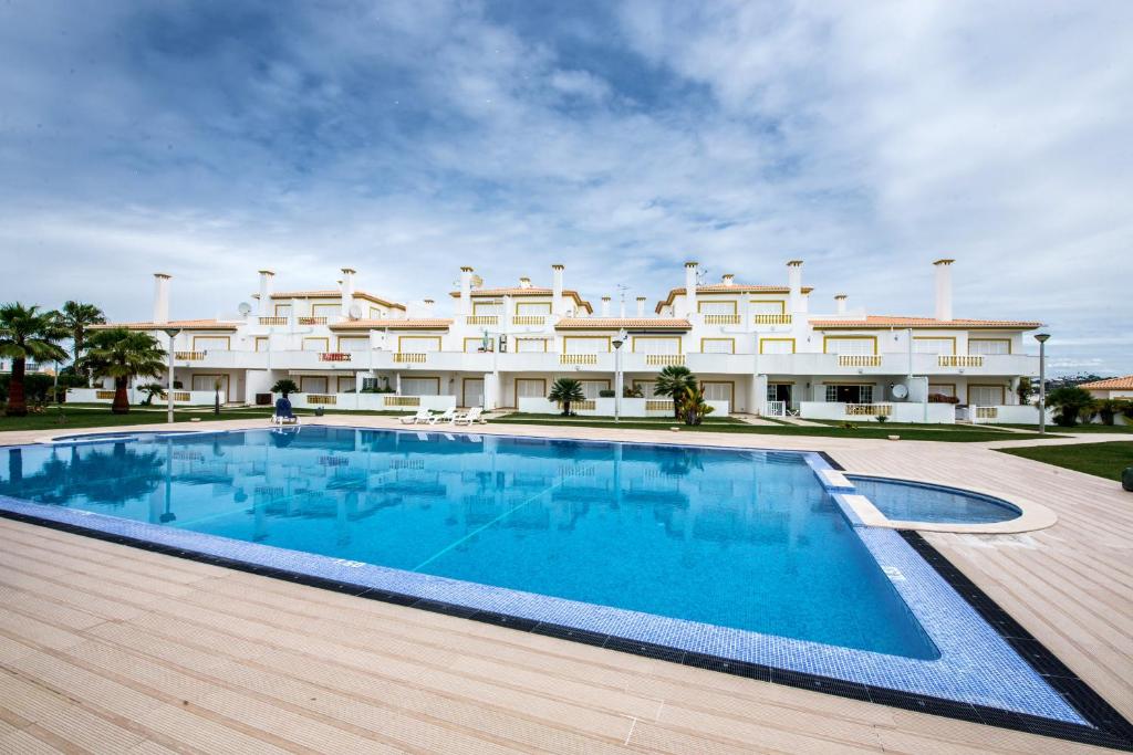 a swimming pool in front of a large building at Apartment O Monte C in Albufeira