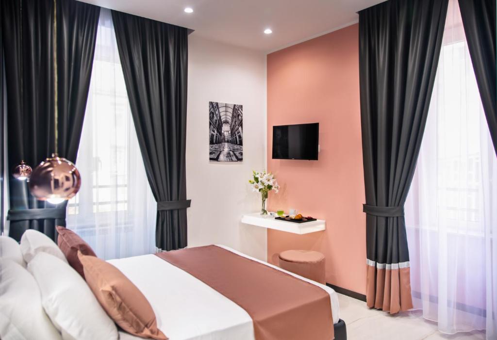 een slaapkamer met roze muren en zwarte gordijnen bij La Lepre Napoli in Napels