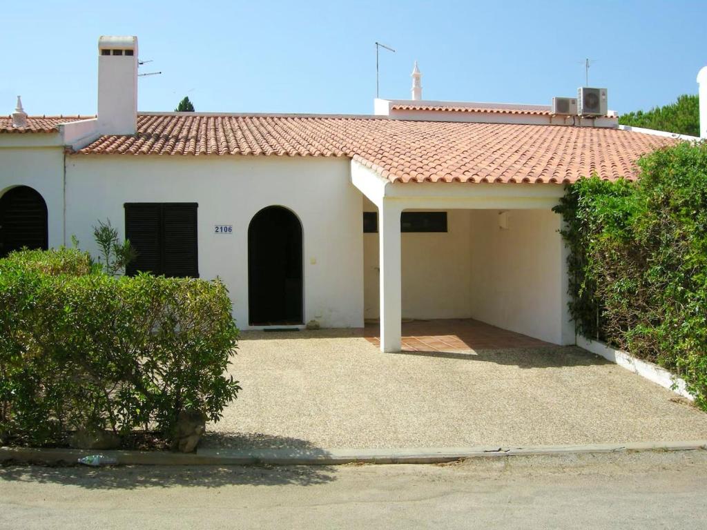 a white house with a red roof at 2 bedrooms house at Albufeira 400 m away from the beach with furnished garden in Albufeira