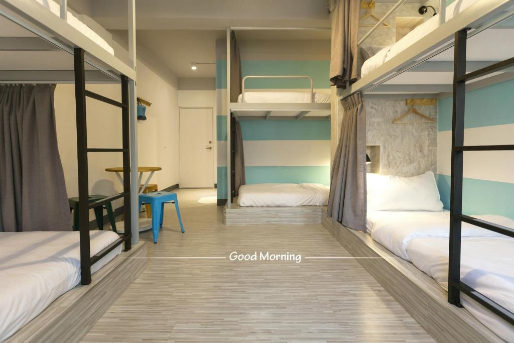 a room with two bunk beds and a table at Bayhouse Comfortel Hualien Hostel in Hualien City