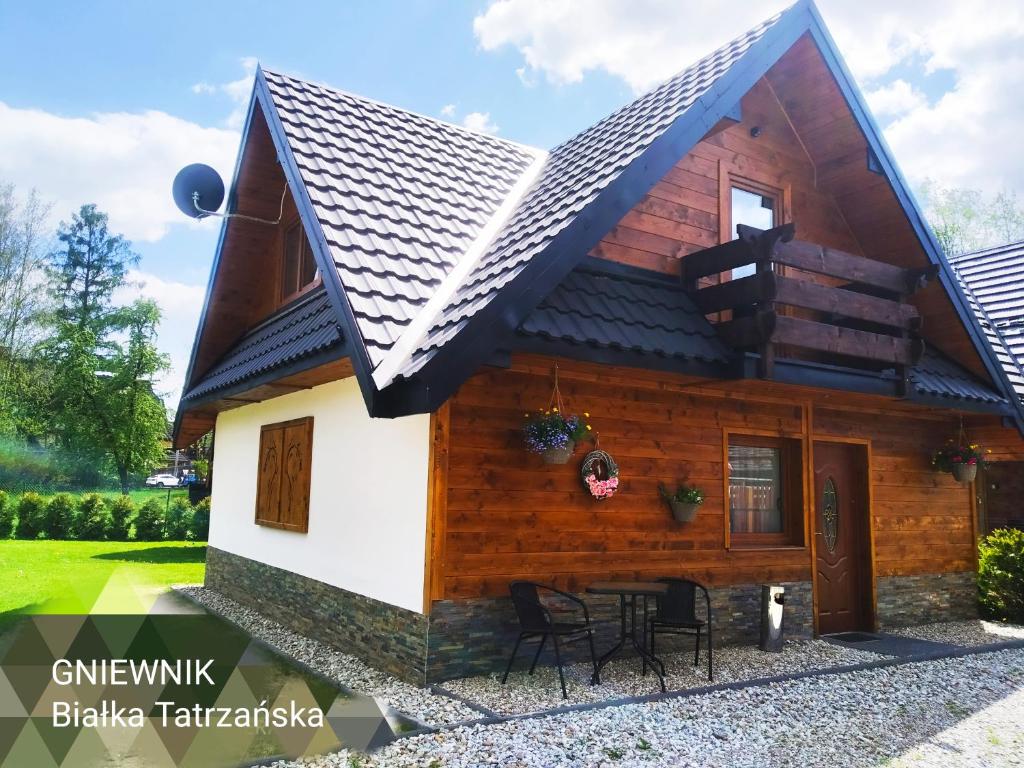 Cette petite maison en bois est mansardée. dans l'établissement Gniewnik, à Białka Tatrzańska
